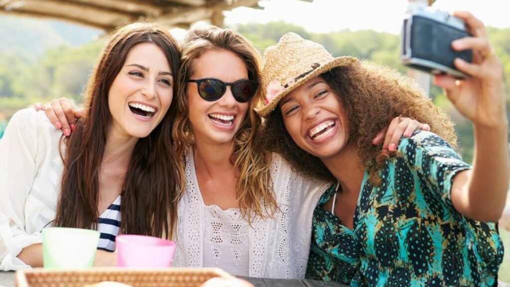 Three Women Sitting on the Bench Taking a Selfie